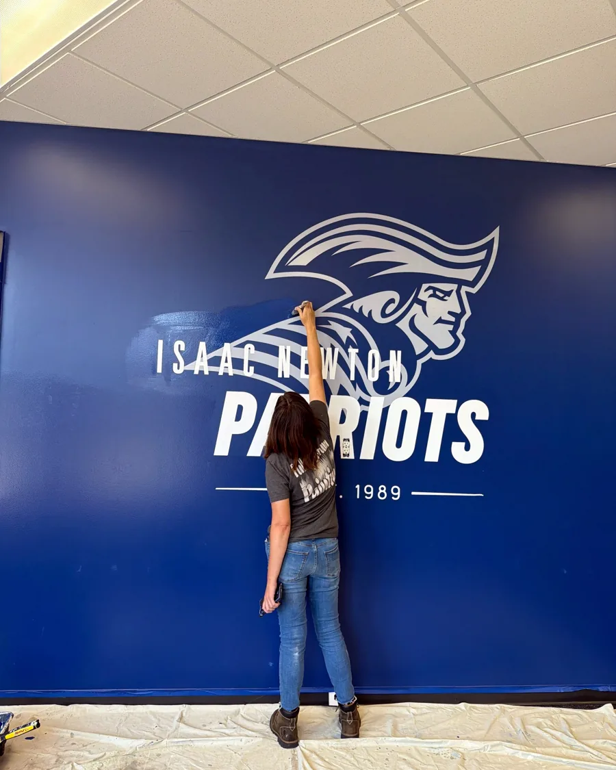 Full Spectrum Painting painting the Patriots wall graphic at Isaac Newton Christian Academy